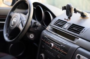 Enterijer automobila u kojem se vidi i držač za telefon.