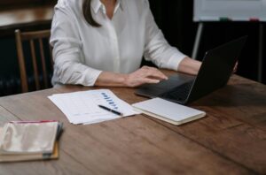 Žena kuca na laptopu.