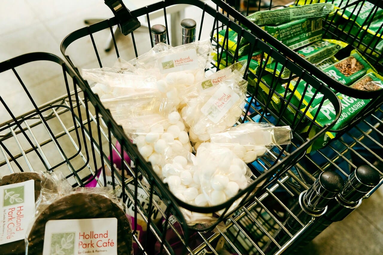 Metalna kolica puna plastičnih kesa sa belim okruglim bombonama